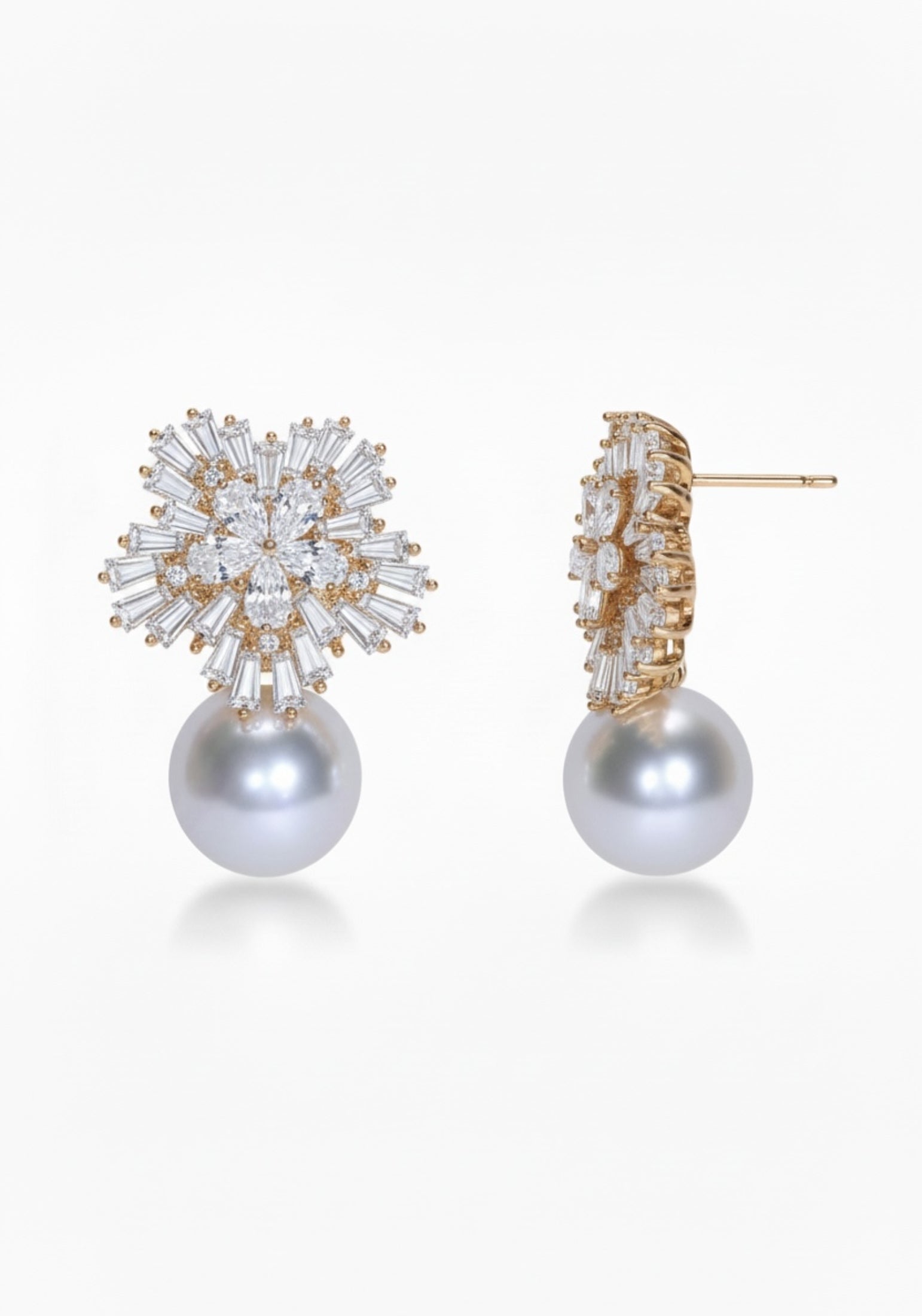 Pair of pearl earrings with gold and crystal embellishments on a white background
