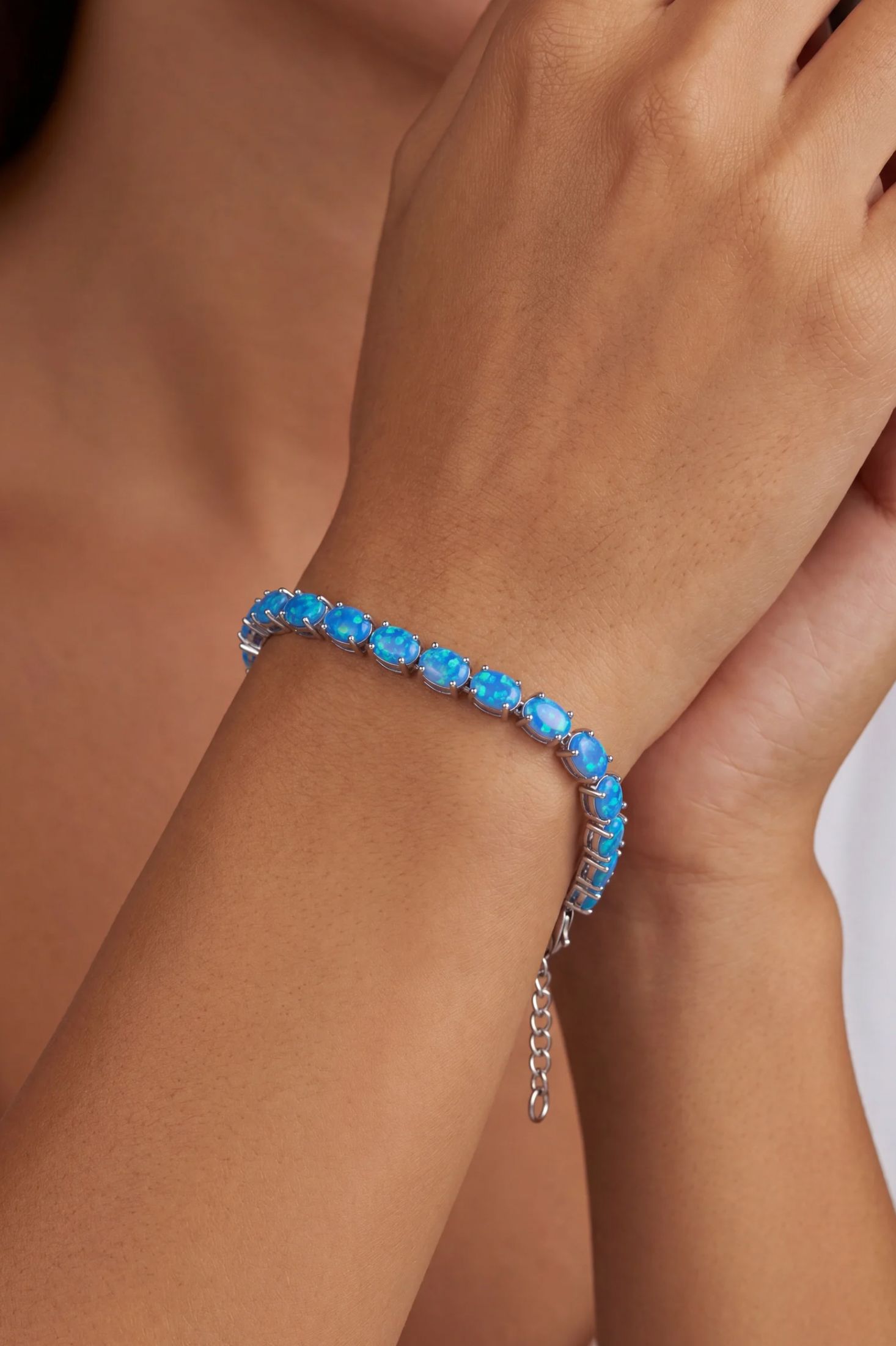 Angled view of Blue Opal Tennis Bracelet Silver, showing silver finish and the jewellery profile.