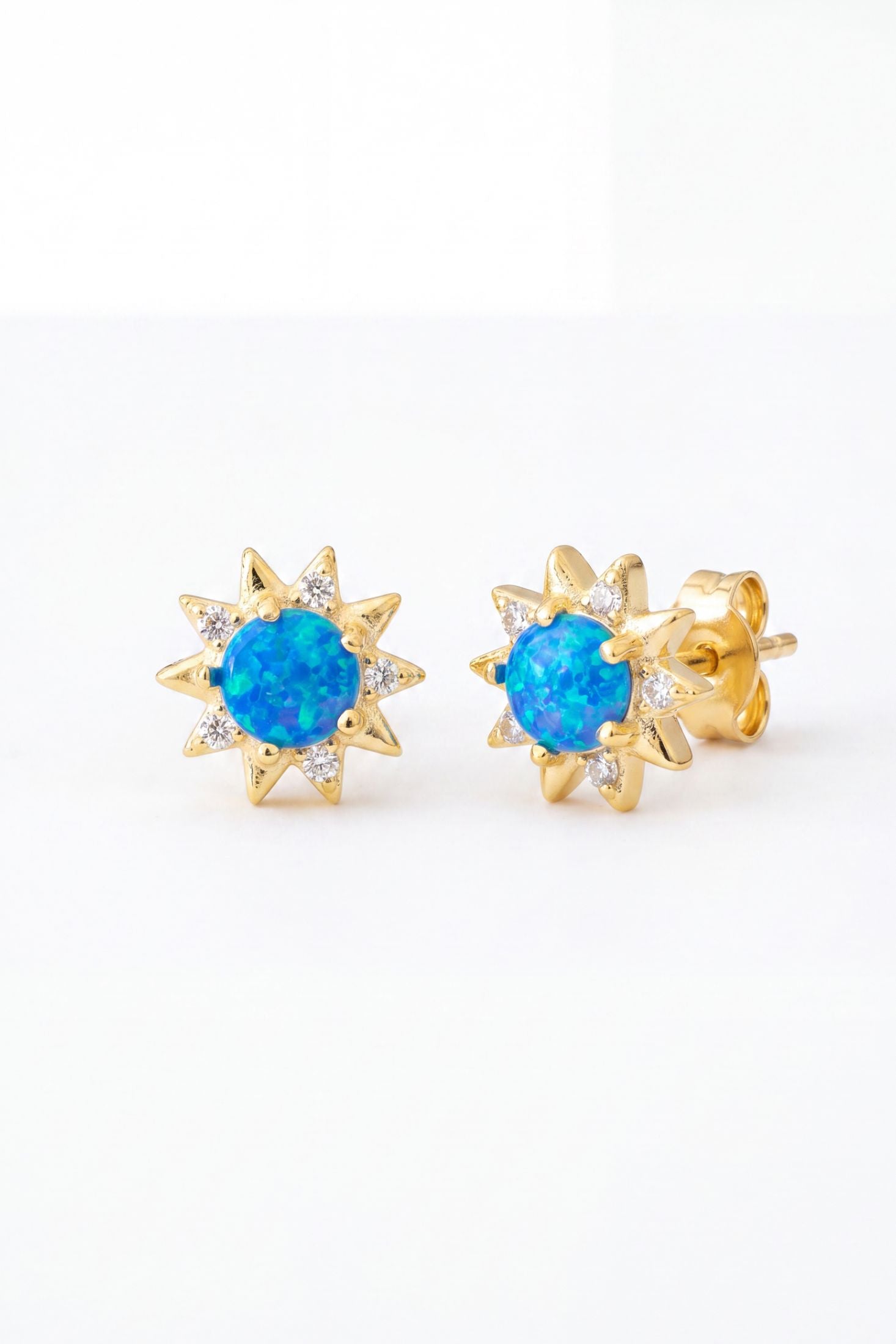 Angled view of Sunflower Blue Opal Stud Earrings Gold, showing flower design, gold finish and the jewellery profile.