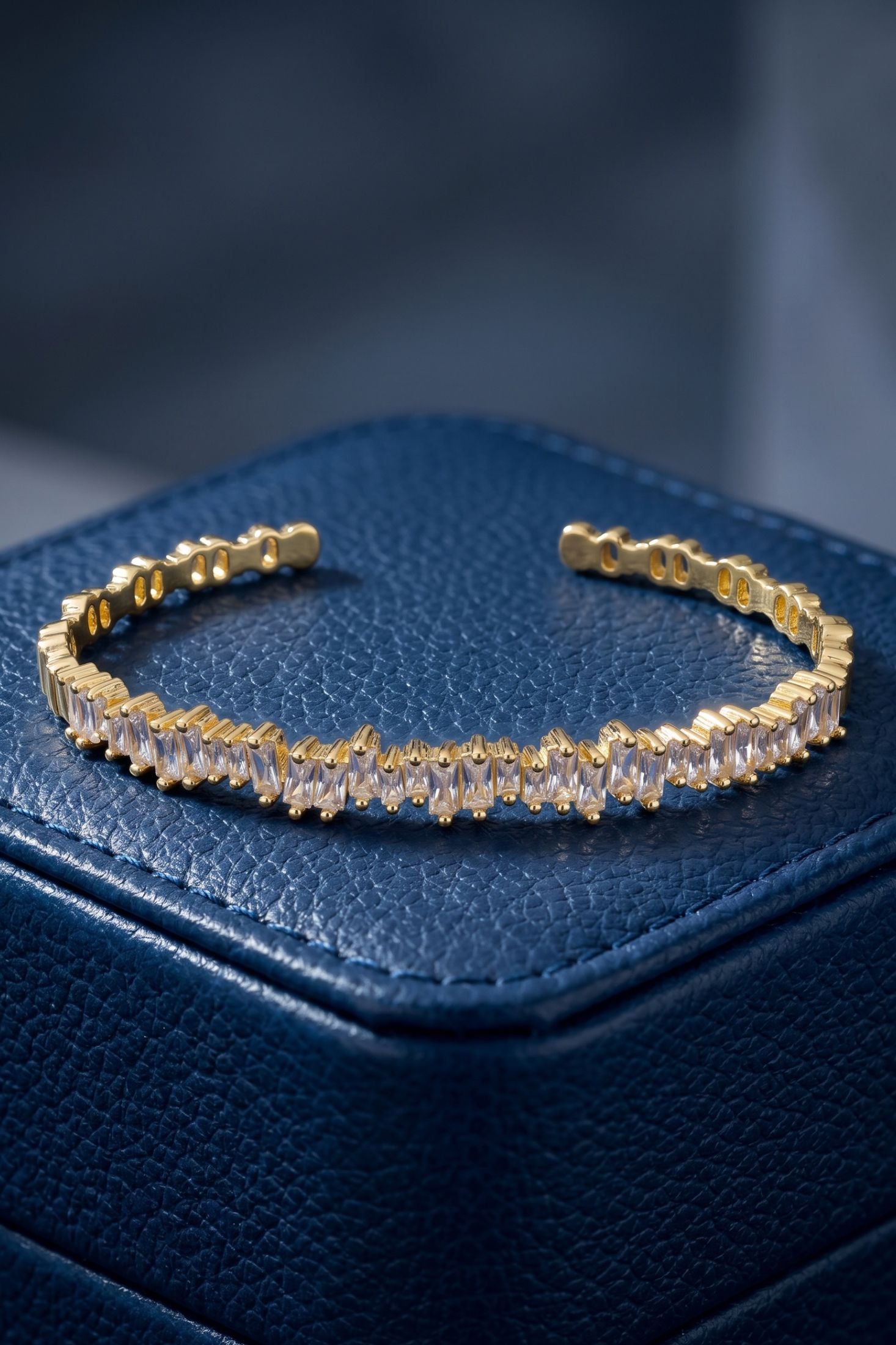 Angled view of Baguette Ice Cuff Bangle Gold White, showing gold finish and the jewellery profile.