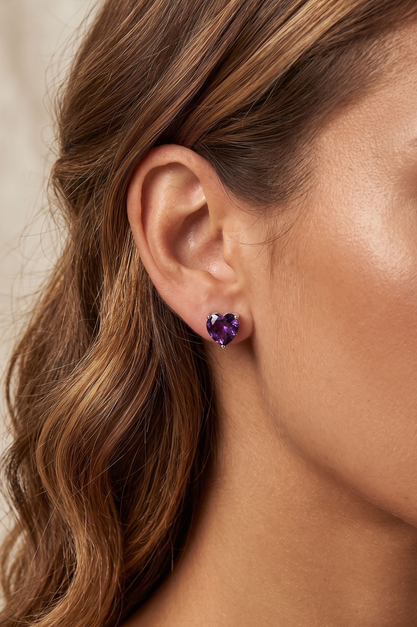 Angled view of Amore Heart Amethyst Stud Earrings Silver, showing heart design, amethyst detailing, silver finish and the jewellery profile.