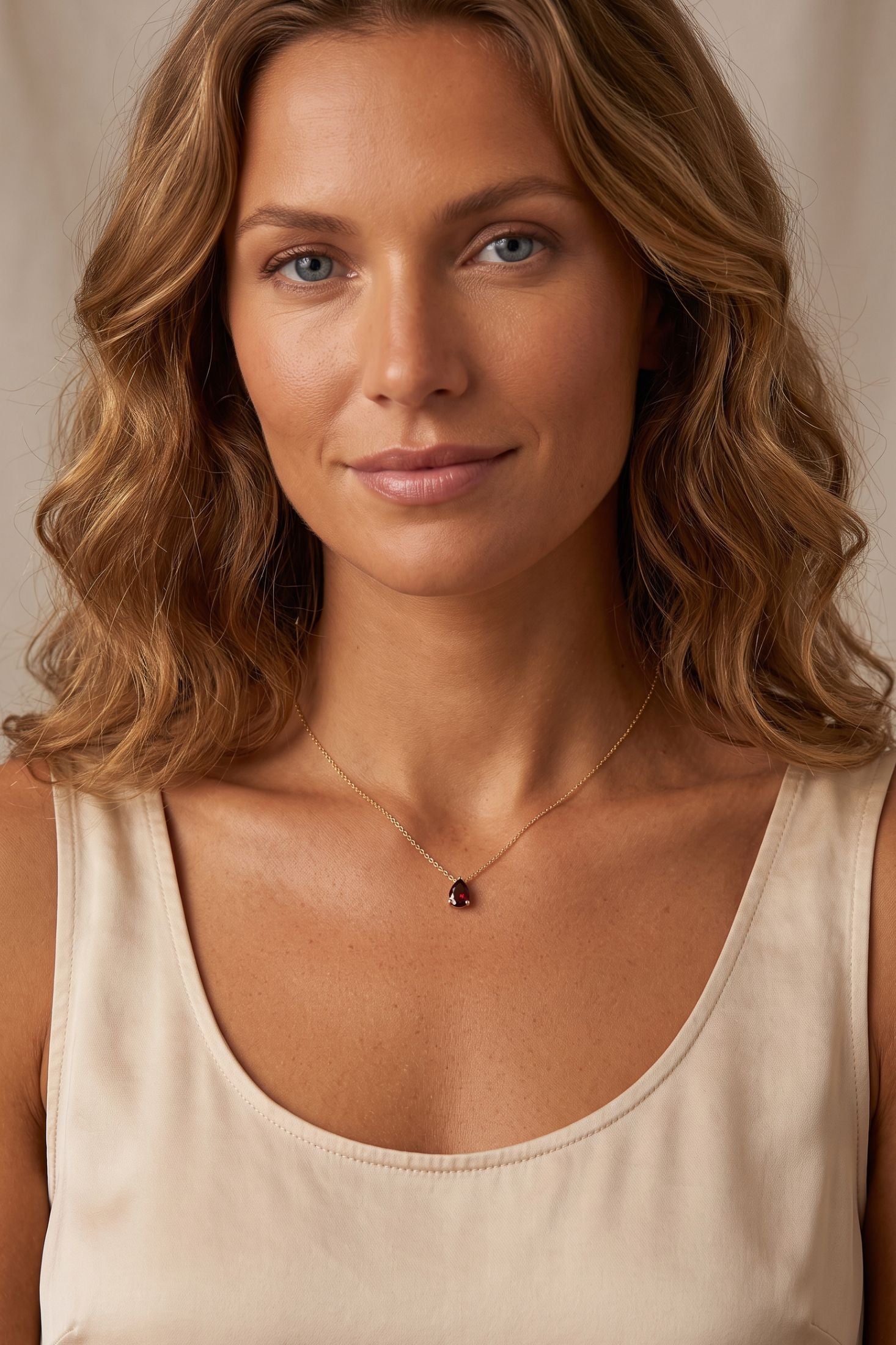 Angled view of Adele Teardrop Necklace Gold Ruby, showing ruby detailing, gold finish and the jewellery profile.