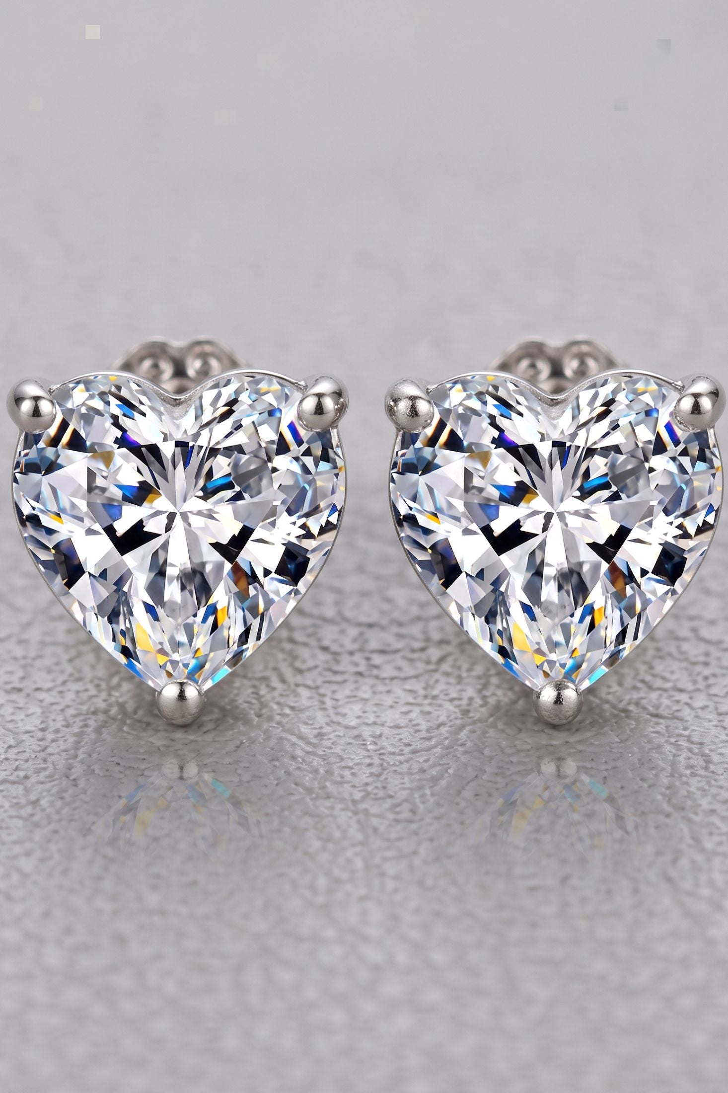 Angled view of Amore Heart Moissanite Stud Earrings Silver, showing heart design, silver finish and the jewellery profile.