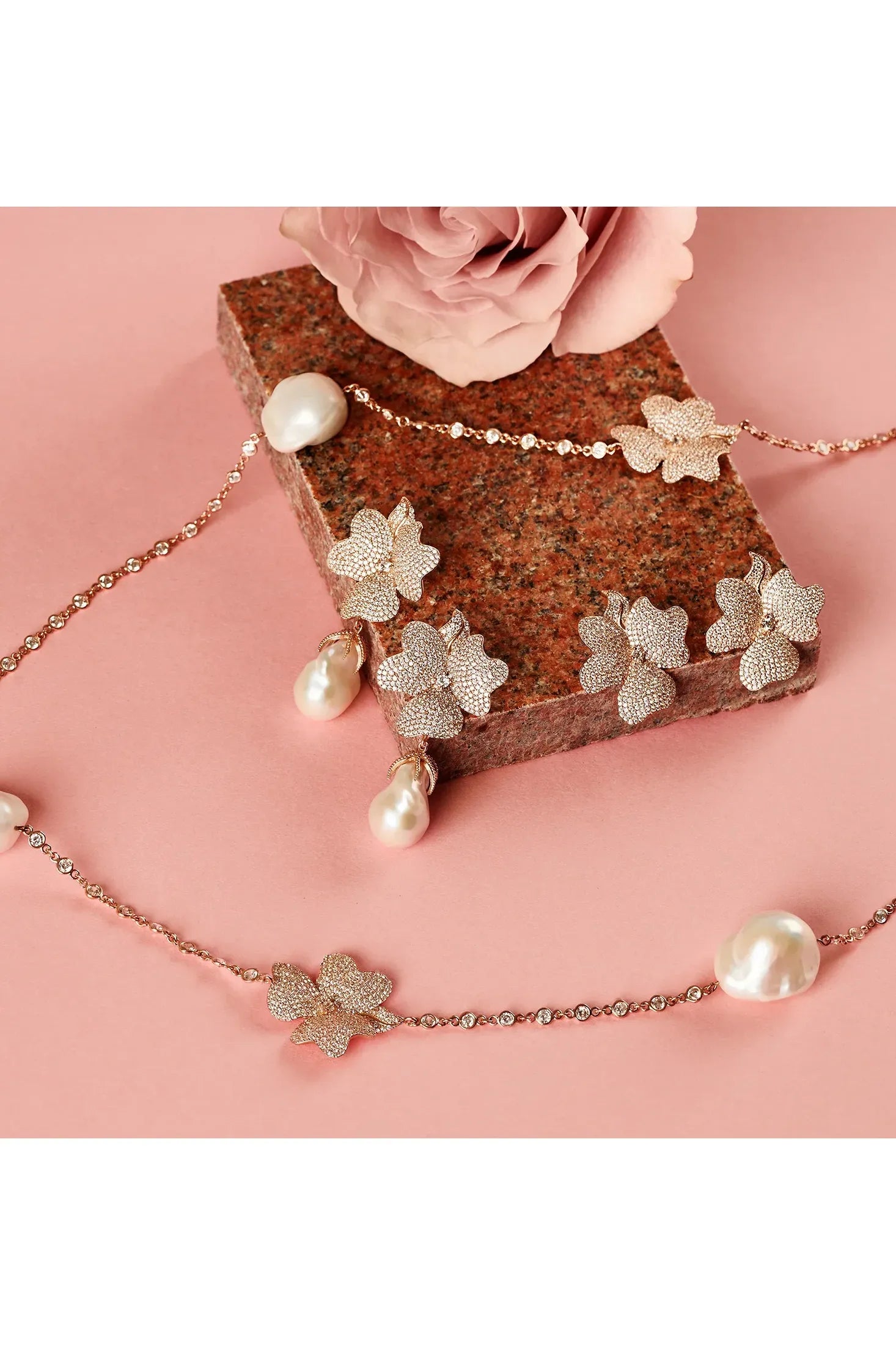 Large rose gold flower earrings with and without pearls, alongside a matching necklace with pearls.