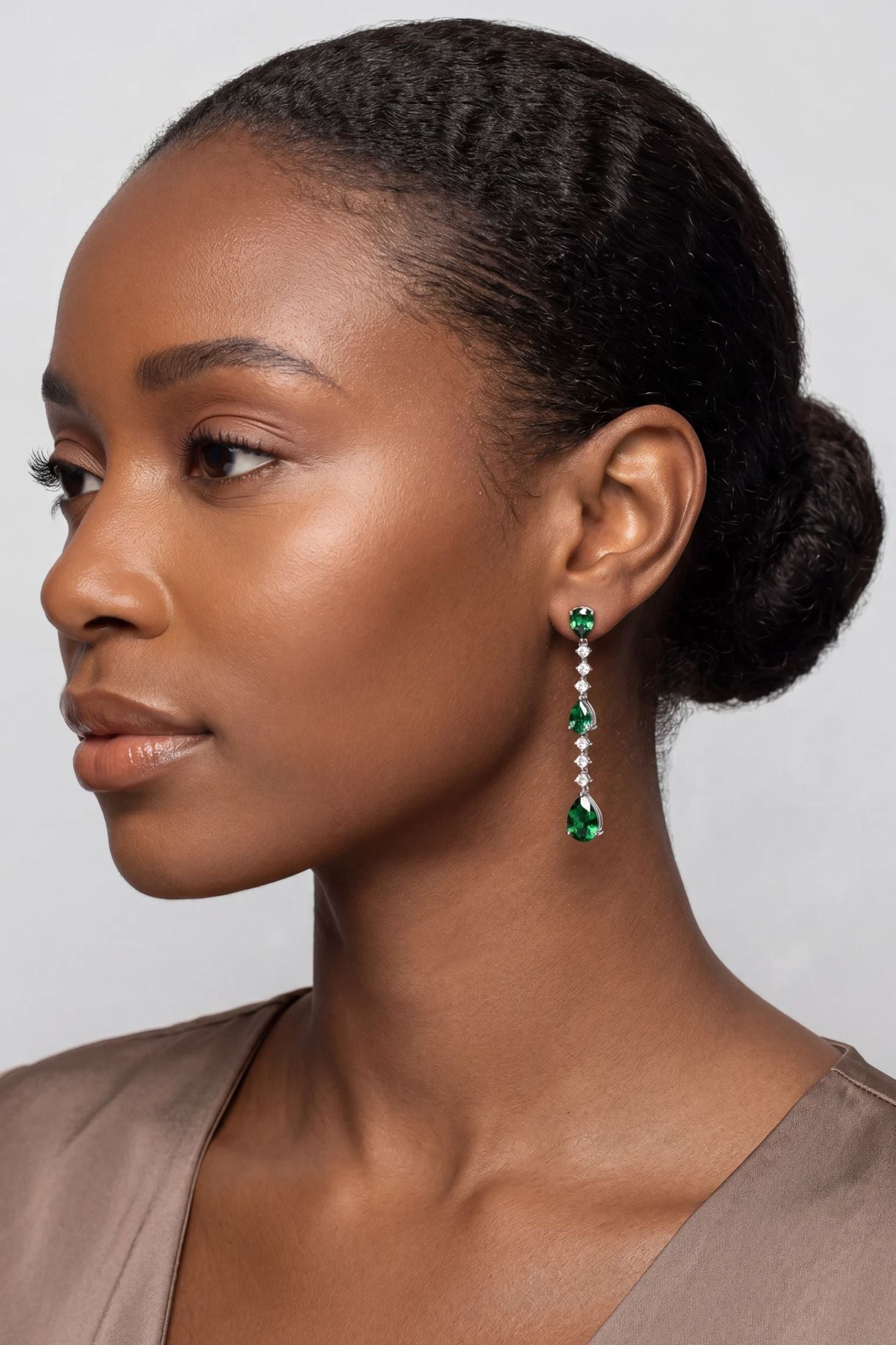 Close-up of Elizabeth Drop Earrings Emerald Silver, highlighting emerald detailing, silver finish.