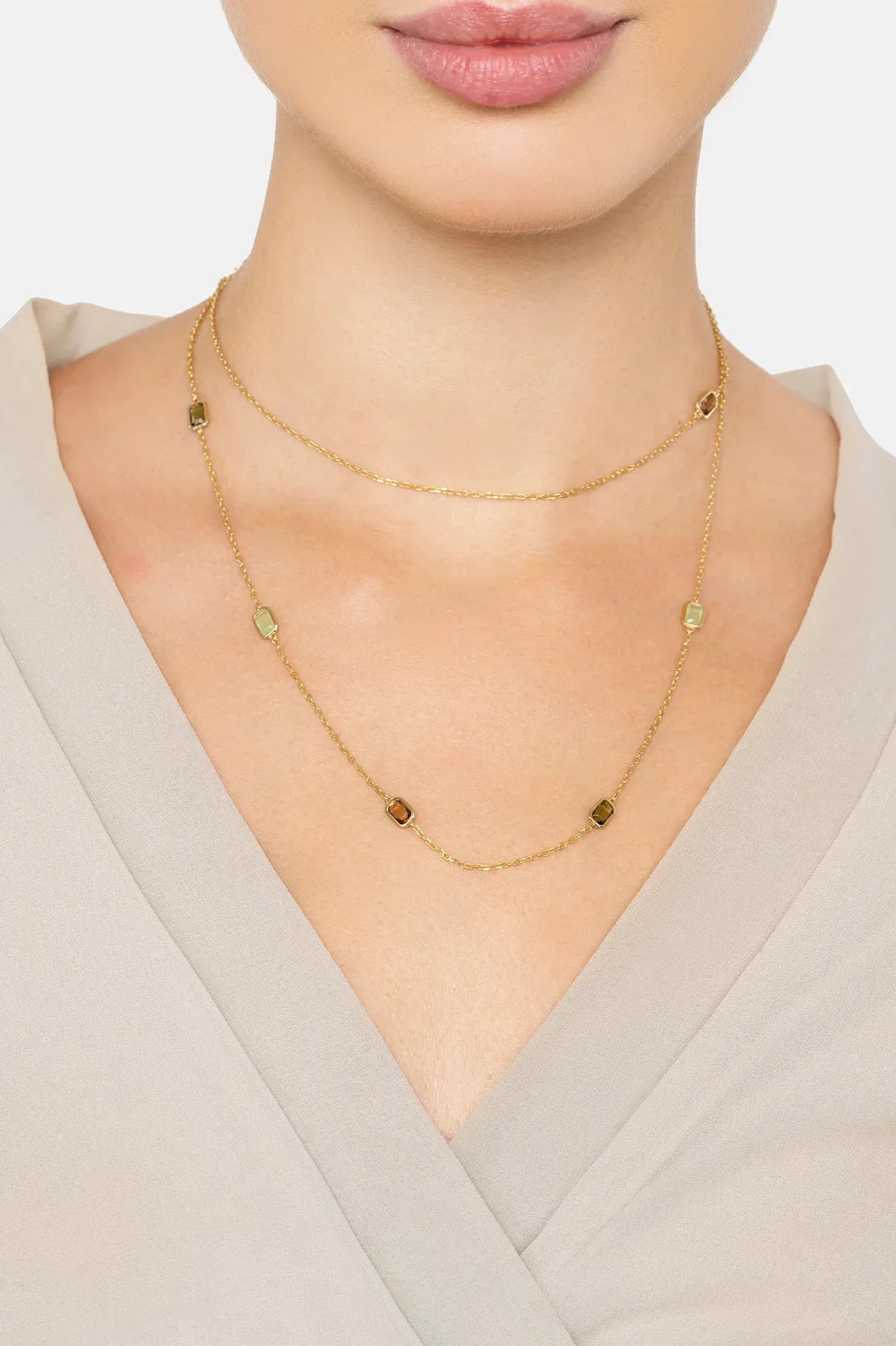 The necklace worn layered by a model.
