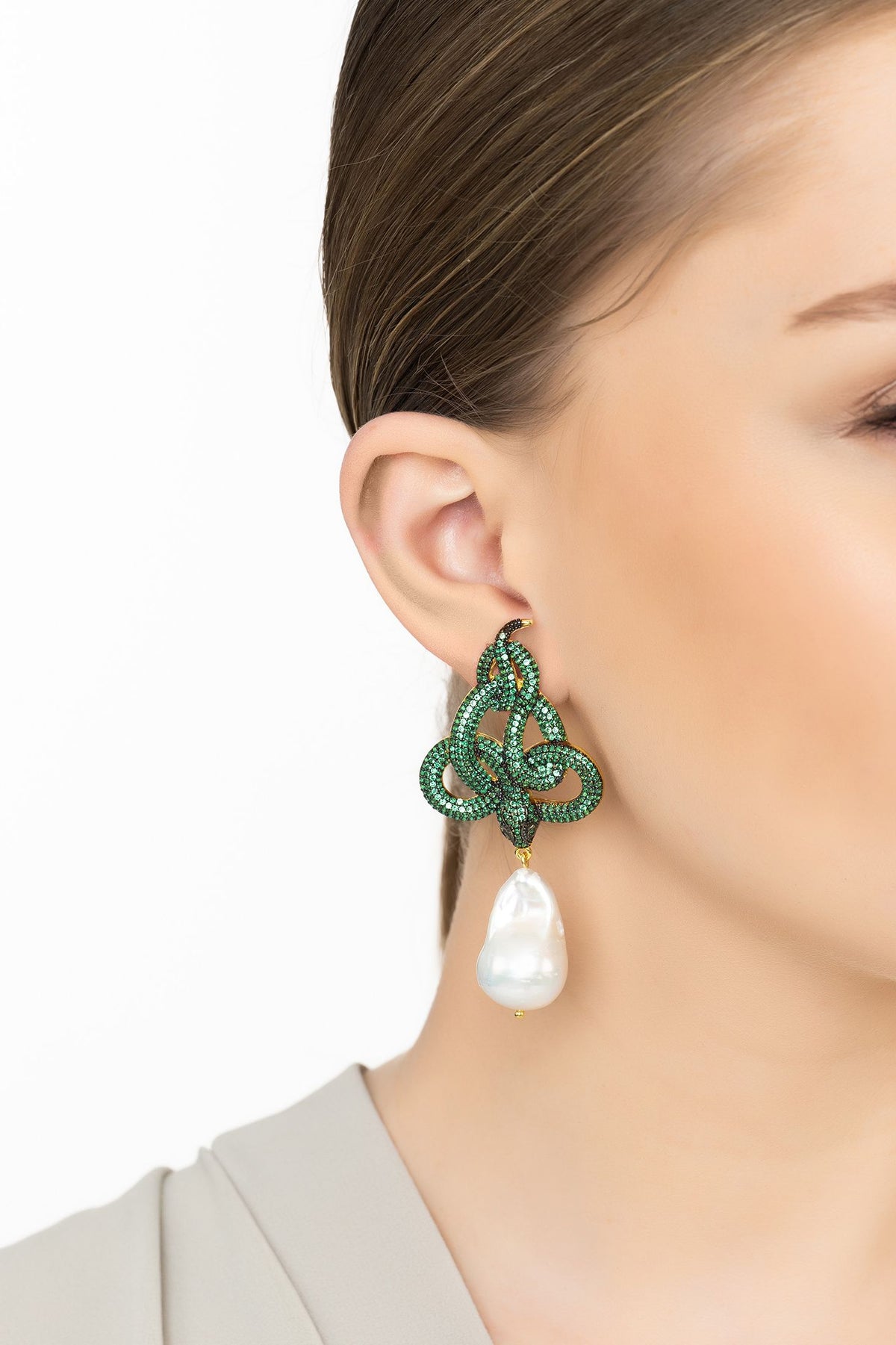 Angled view of Viper Snake Baroque Pearl Drop Earrings Gold Emerald CZ, showing snake design, baroque pearl and pearl detailing, gold finish and the jewellery profile.