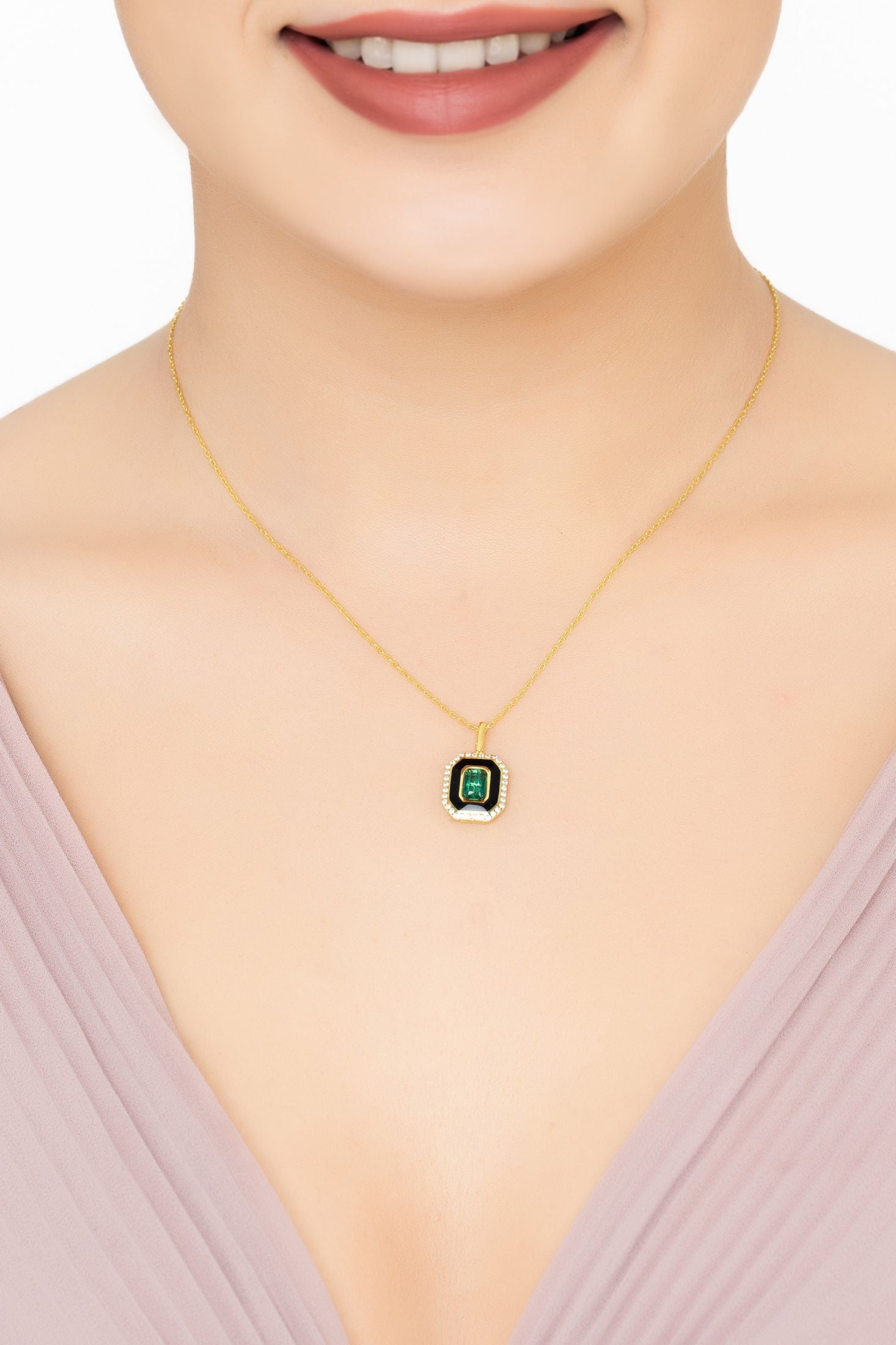 Angled view of Art Deco Emerald And Enamel Pendant Necklace Gold, showing emerald detailing, gold finish and the jewellery profile.