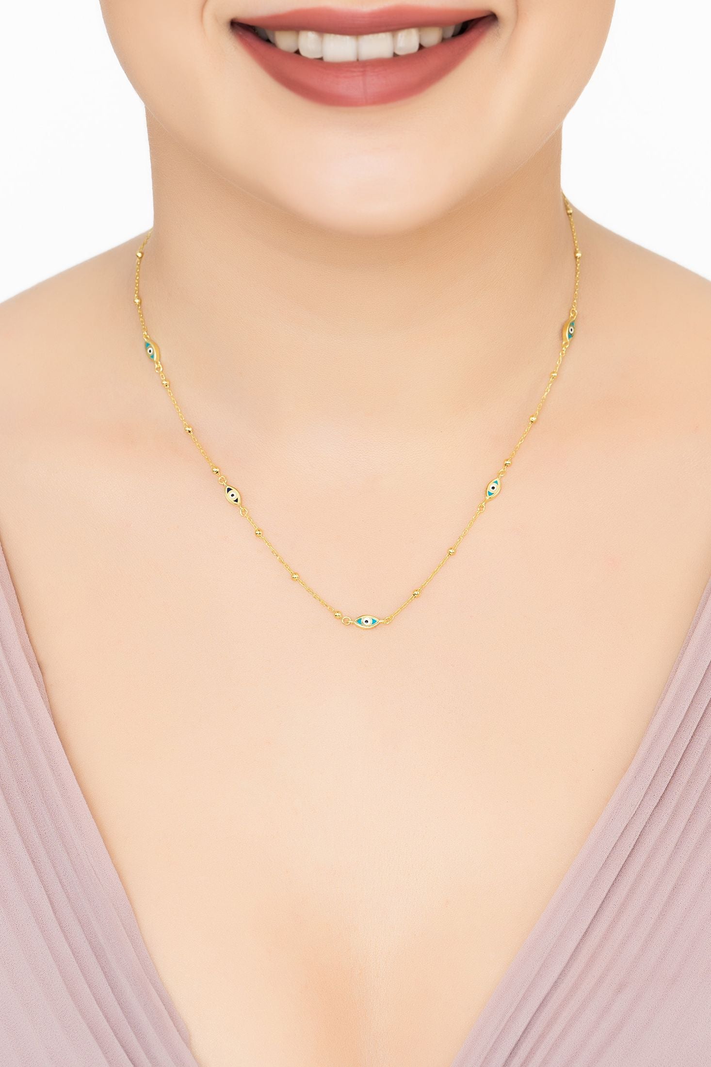 Angled view of Evil Eye Elliptical Beaded Chain Necklace Gold, showing evil eye design, gold finish and the jewellery profile.