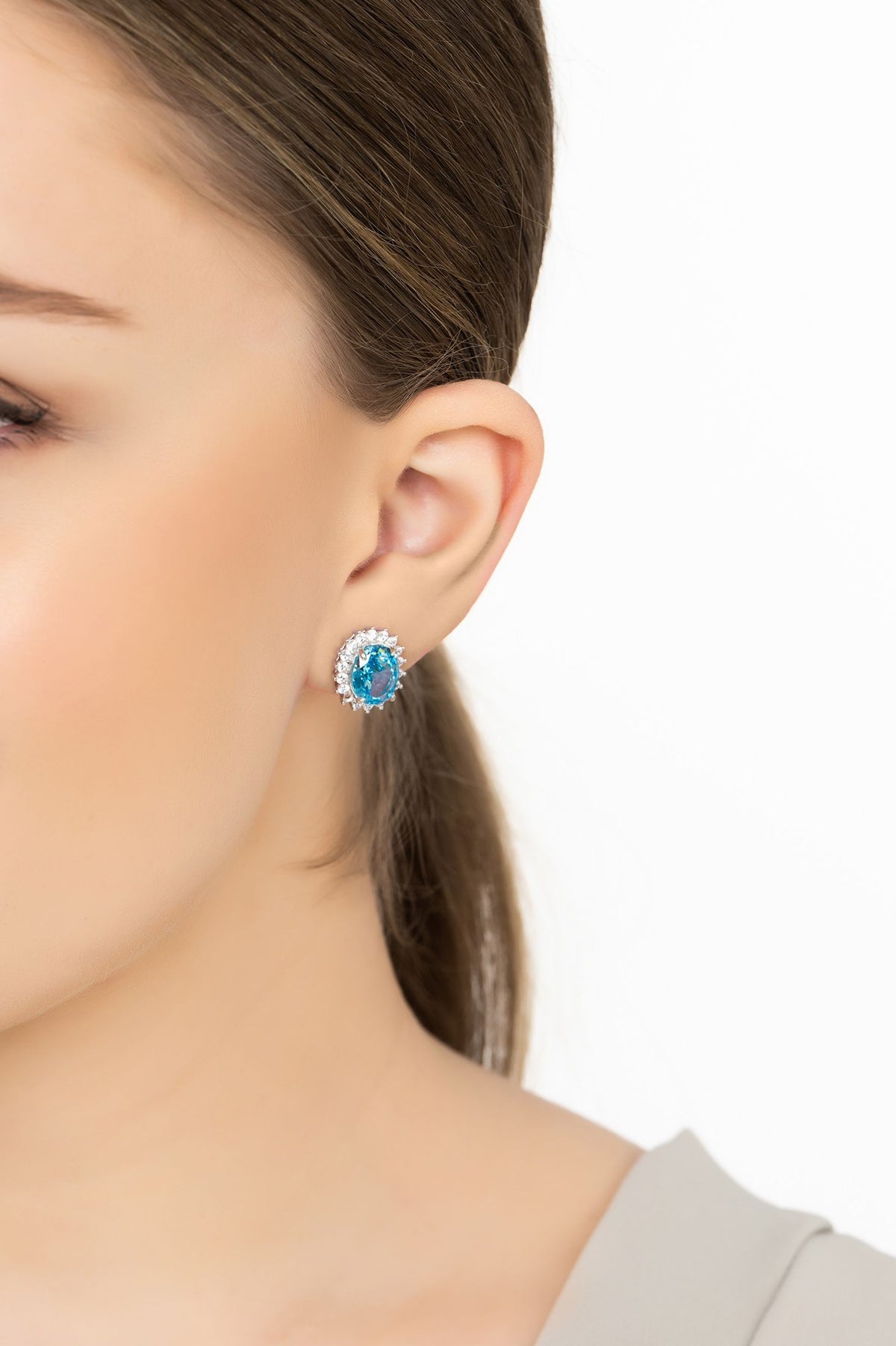 Angled view of Tatiana Oval Blue Topaz Stud Earrings Silver, showing blue topaz detailing, silver finish and the jewellery profile.