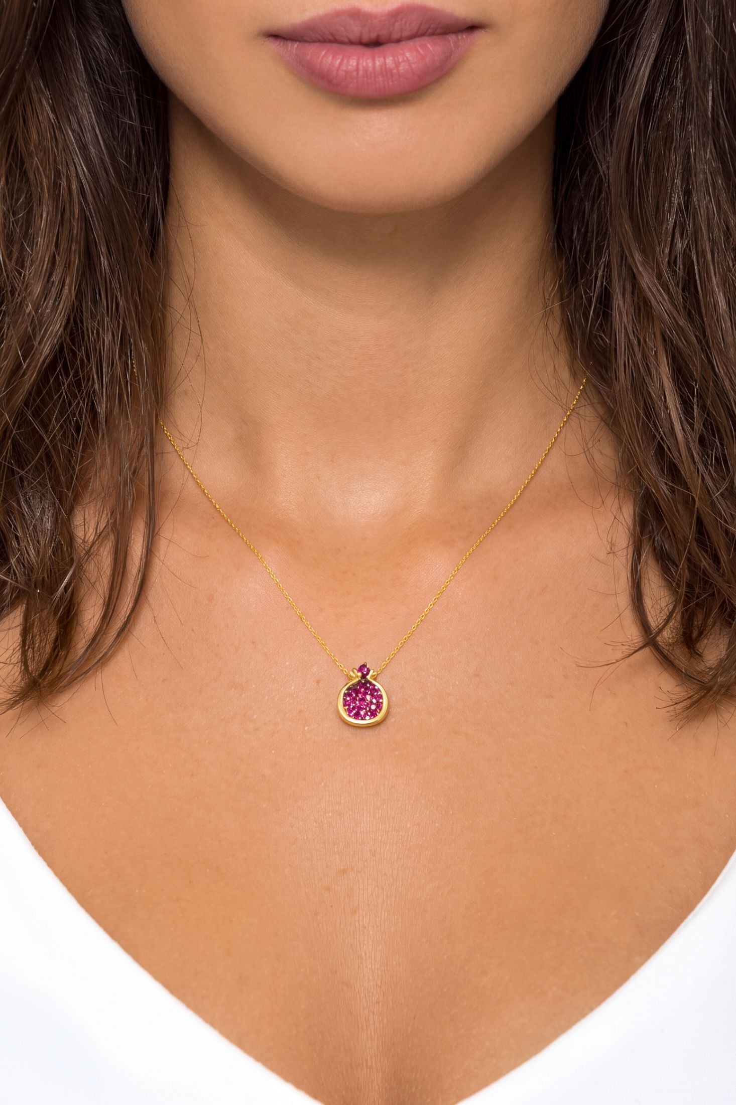 Angled view of Pomegranate Ruby Pink Pendant Necklace Gold, showing ruby detailing, gold finish and the jewellery profile.