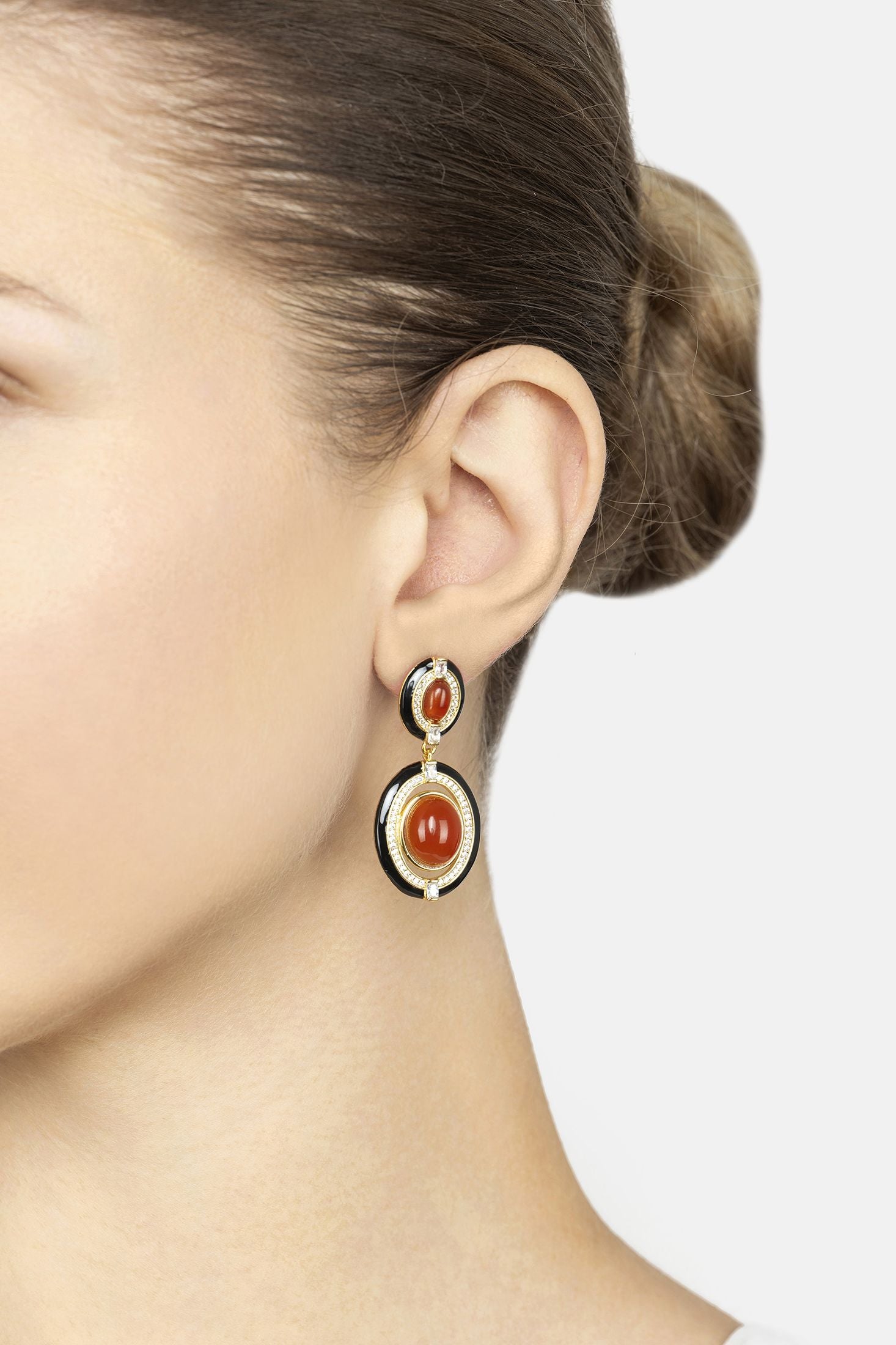 Close-up of a person wearing a pair of earrings with a white background