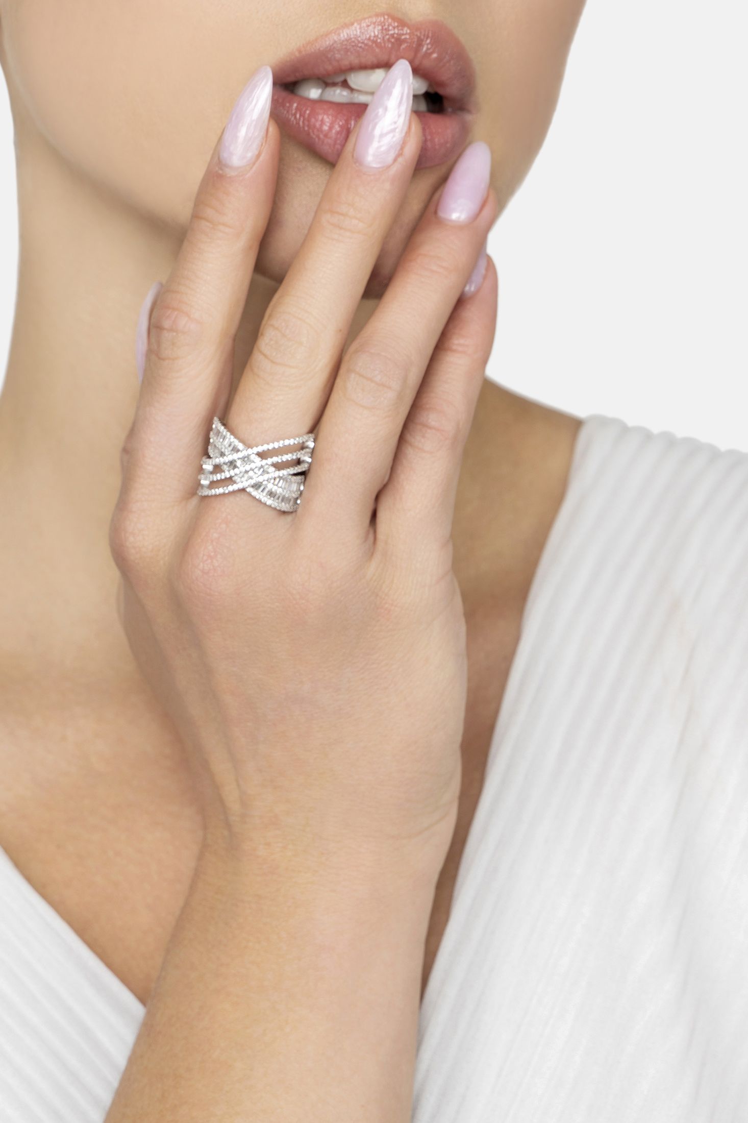 Silver ring on a model's finger with a plain background