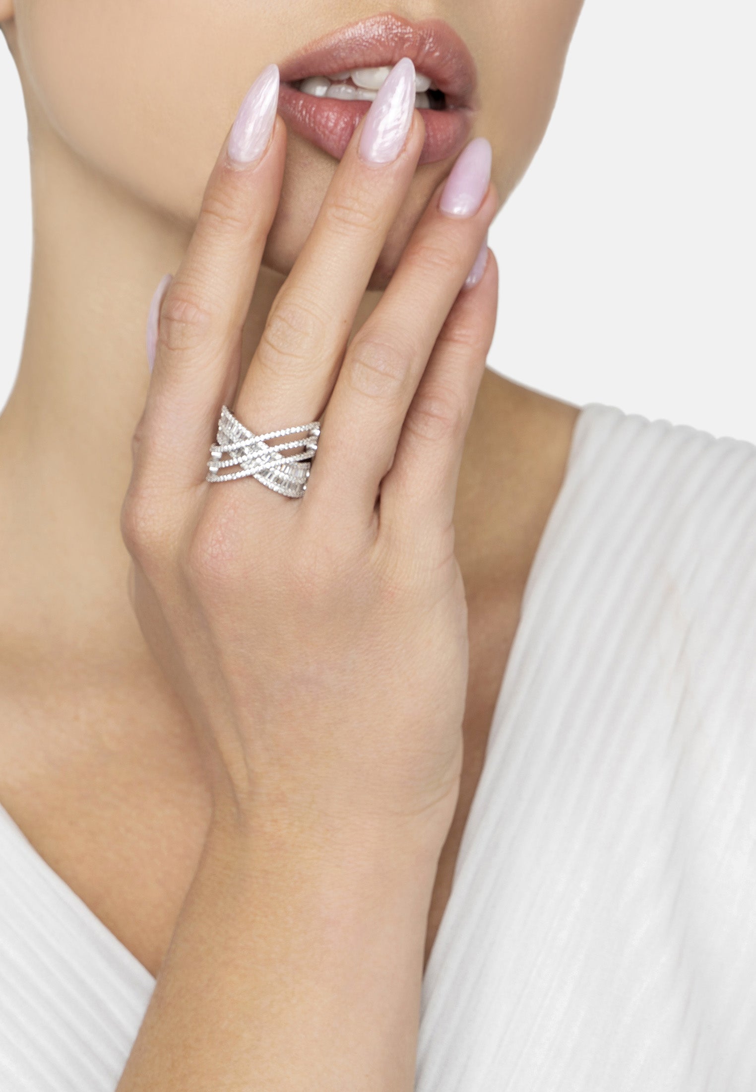 Silver ring on a model's finger with a plain background