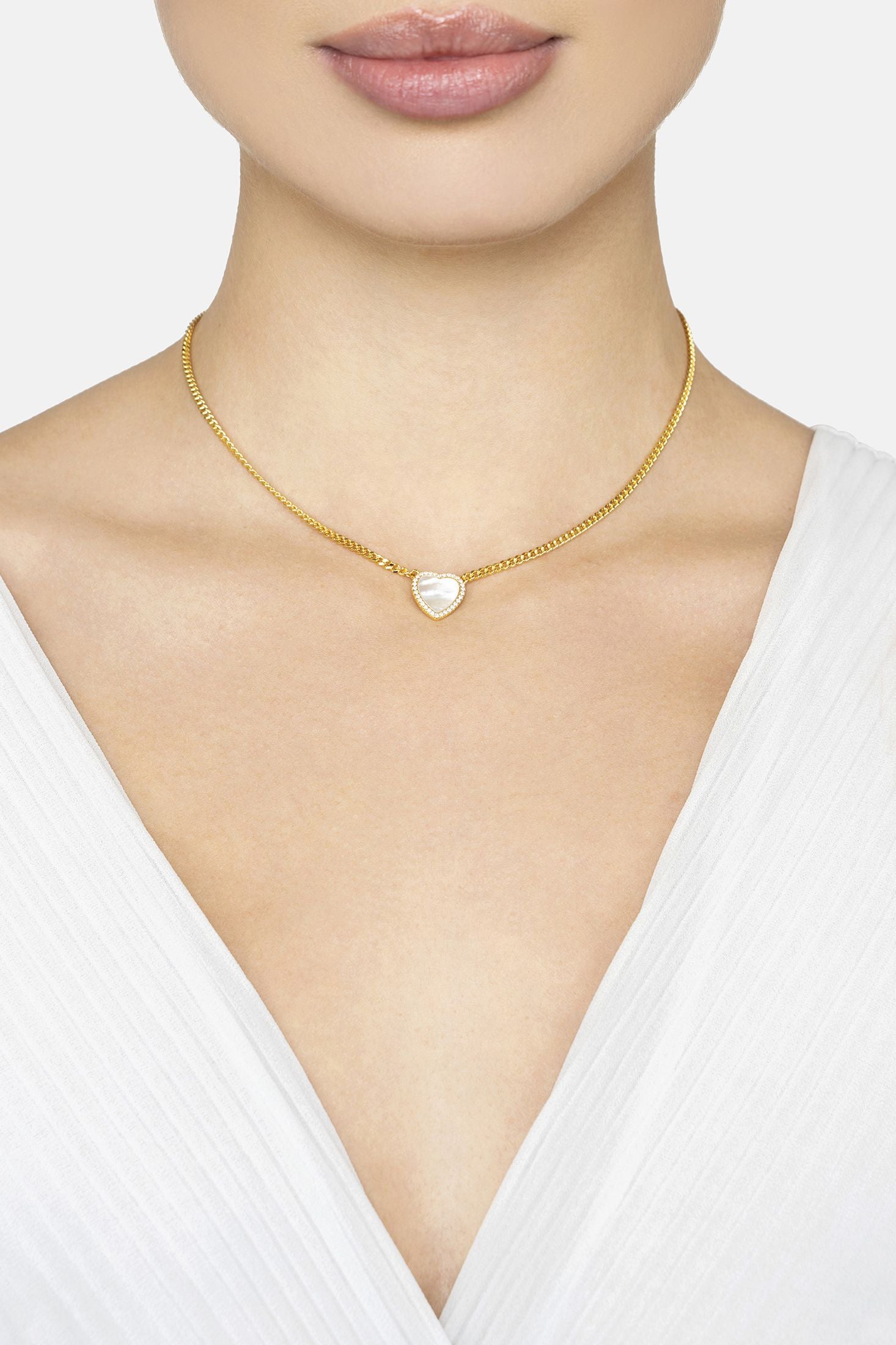 Heart shaped pendant necklace worn by a woman in a white top