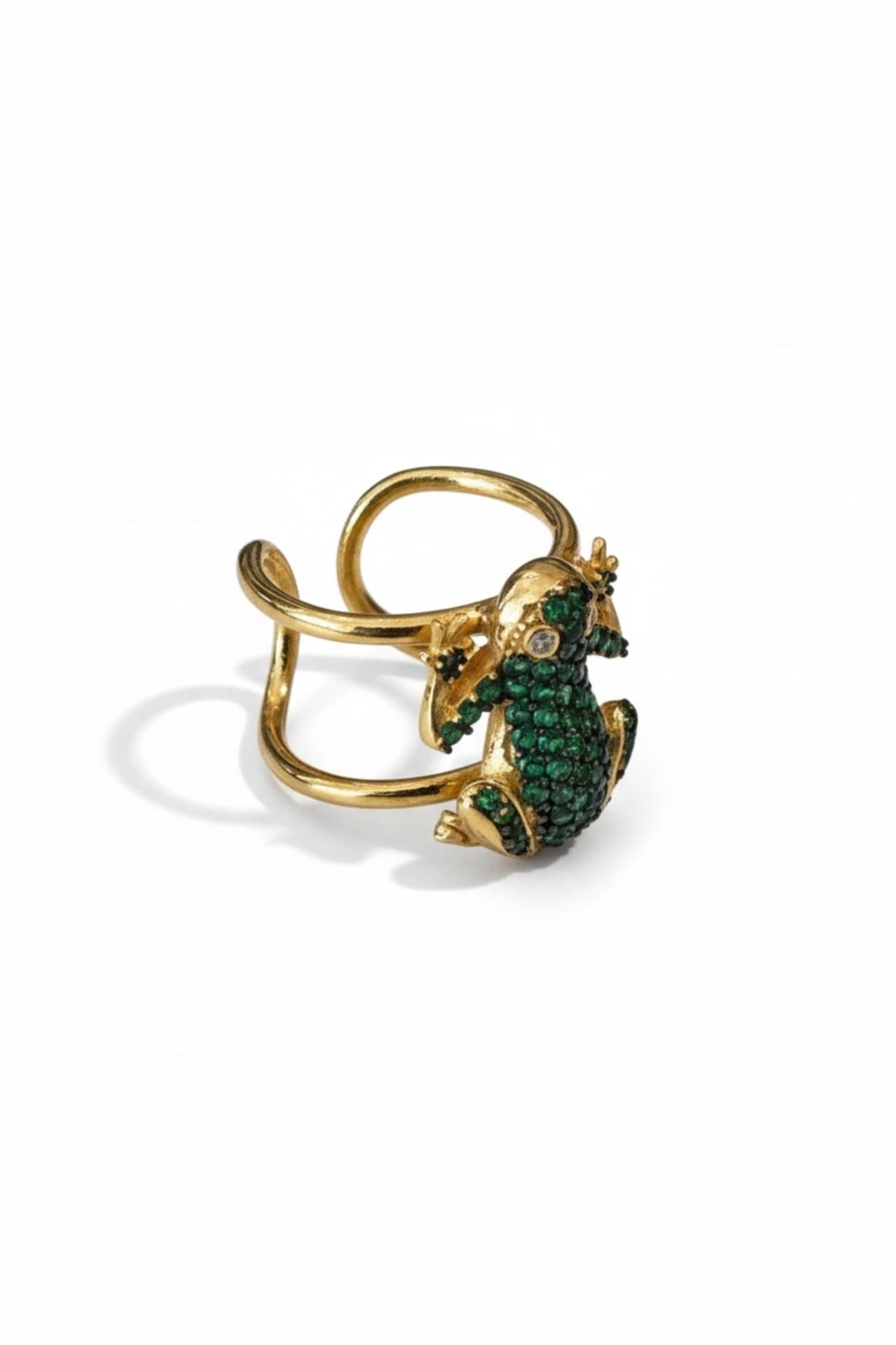 Gold ring with a frog with green gemstones on a white background