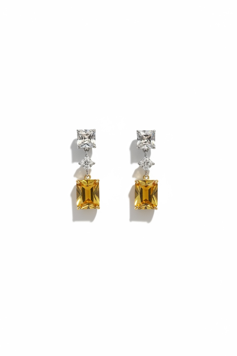 Pair of earrings with yellow gemstones and diamond-like elements on a white background
