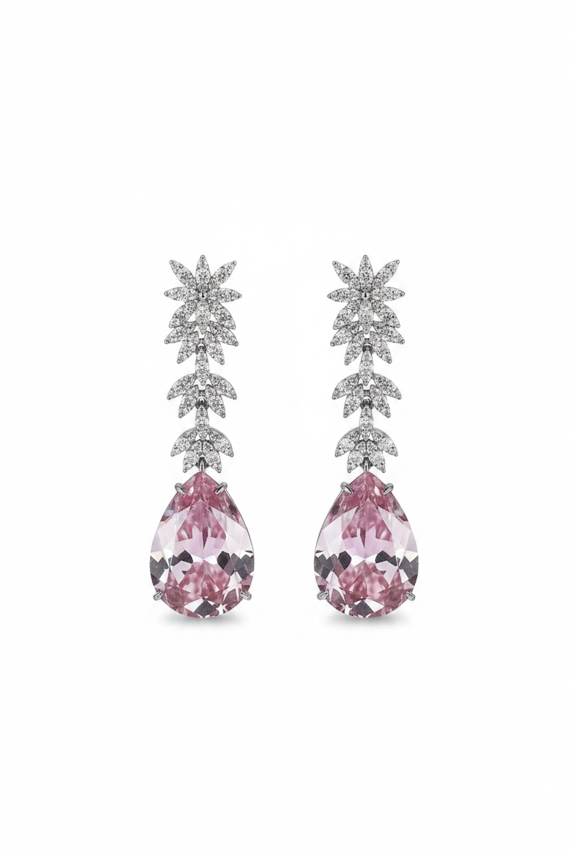 Pair of earrings with pink gemstones and silver foliage-like design on a white background