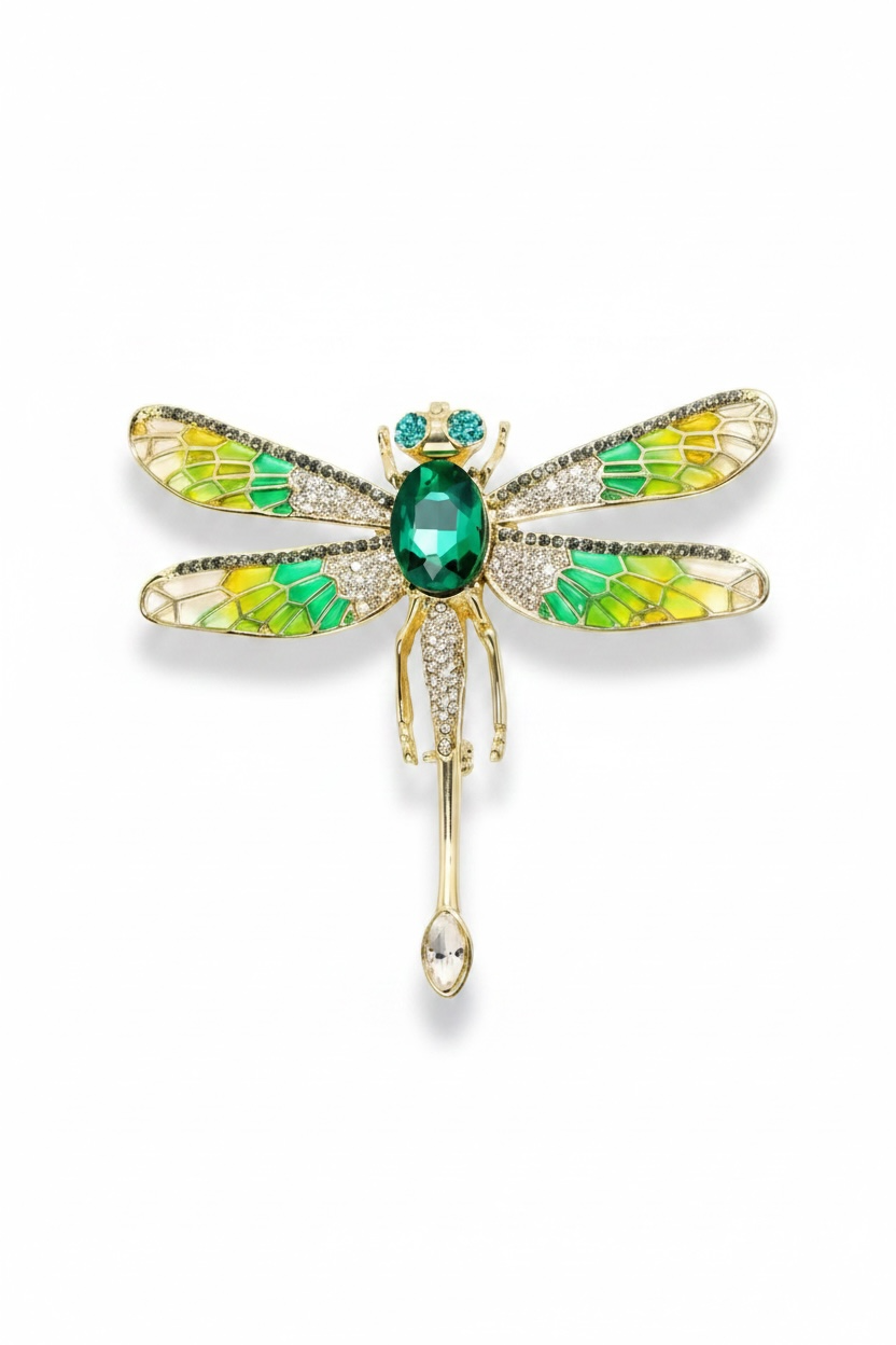 Dragonfly-shaped brooch with green gemstone on a white background