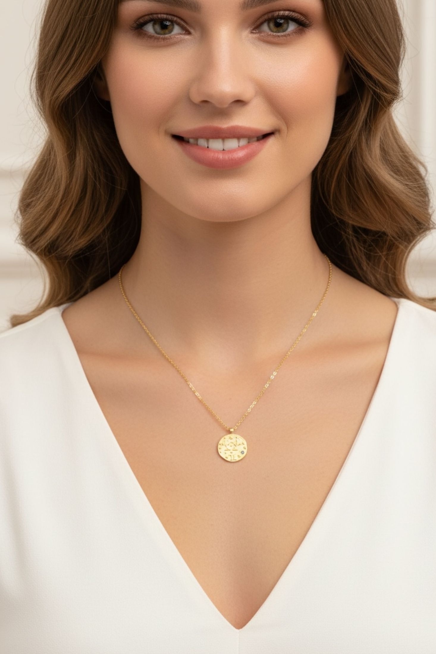 Gold pendant necklaces worn by a model.