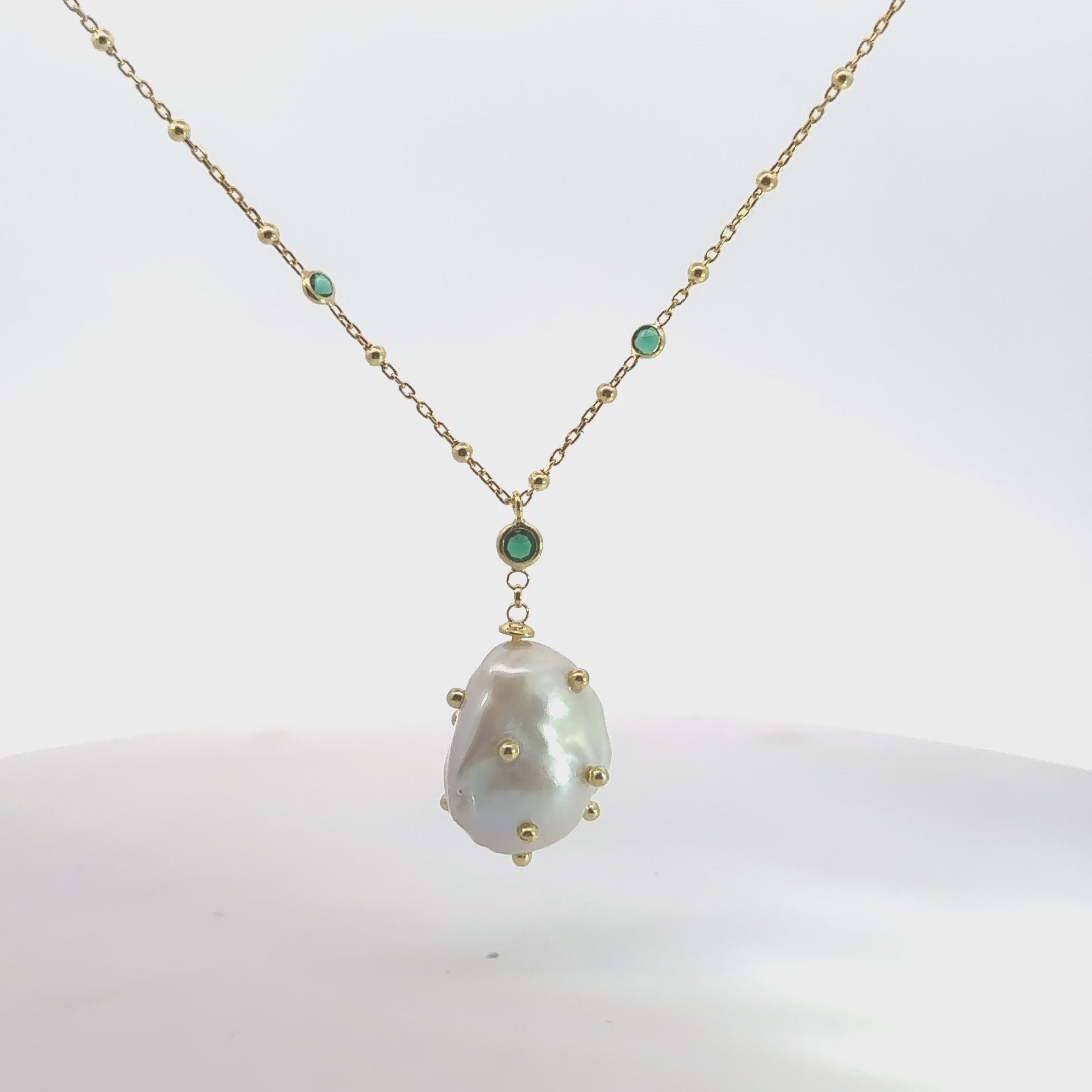 Video of Polka Dot Baroque Pearl Pendant Necklace Gold Emerald, showing the pendant, chain and scale from multiple angles.