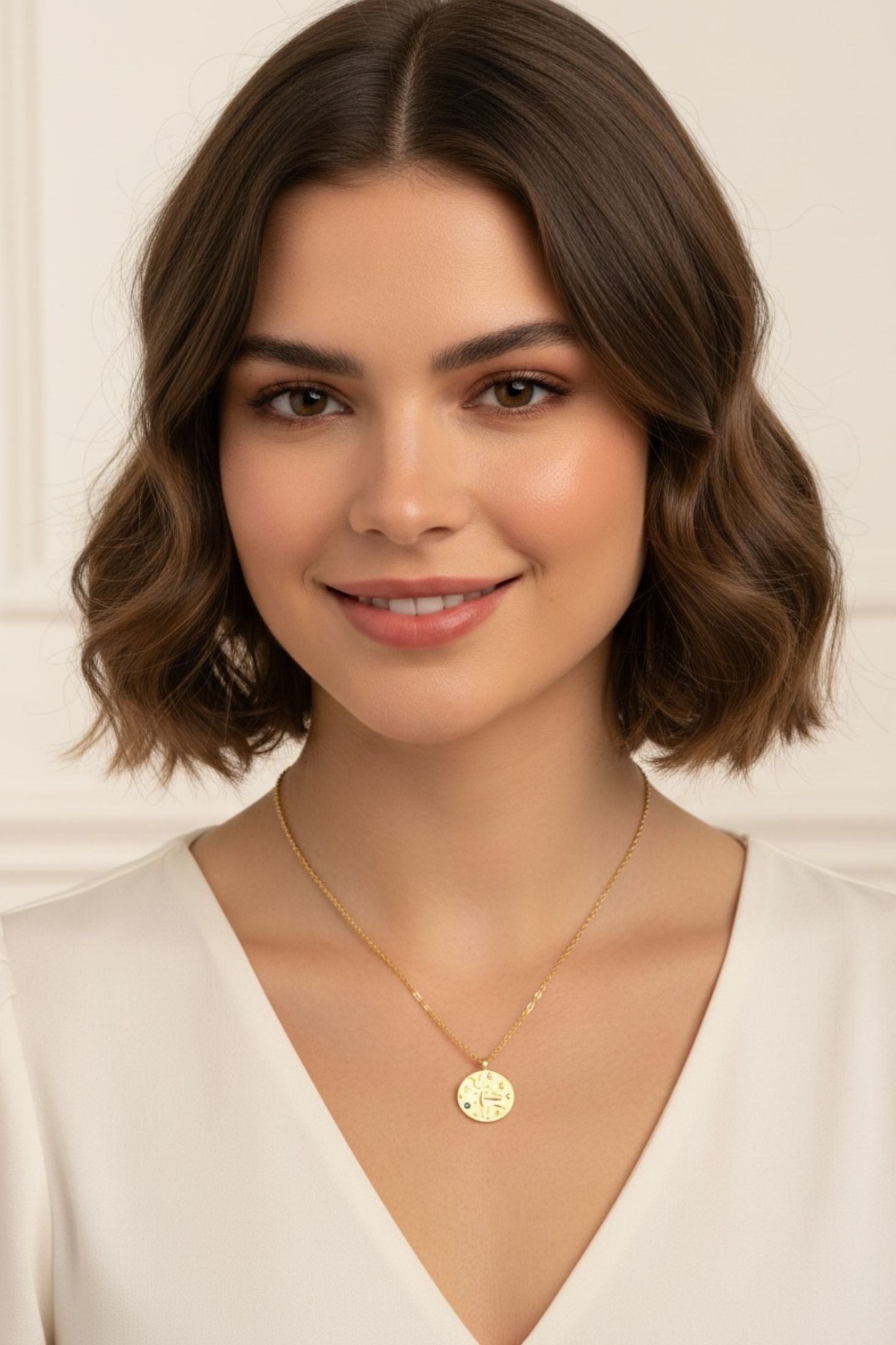 Gold pendant necklace worn by a woman