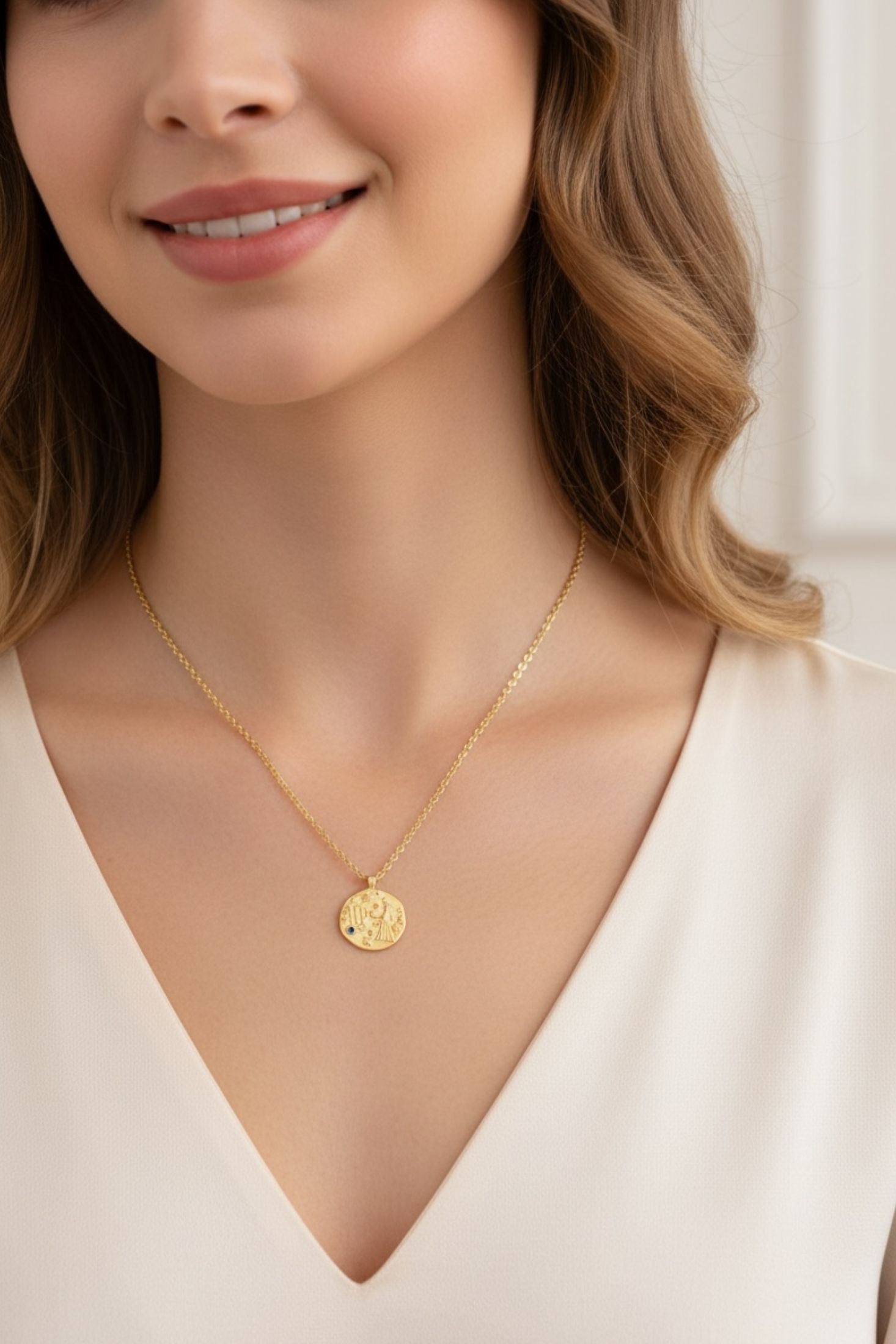 Gold pendant necklace worn by a model.