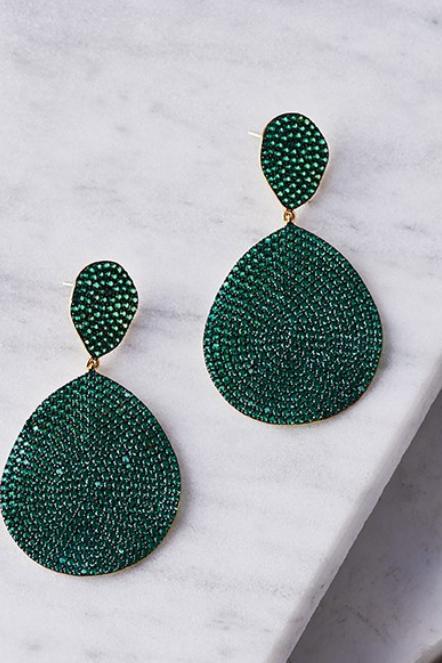 Monte Carlo Earrings Gold Emerald Zircon worn by a model, showing how they sit on the ear and their scale.